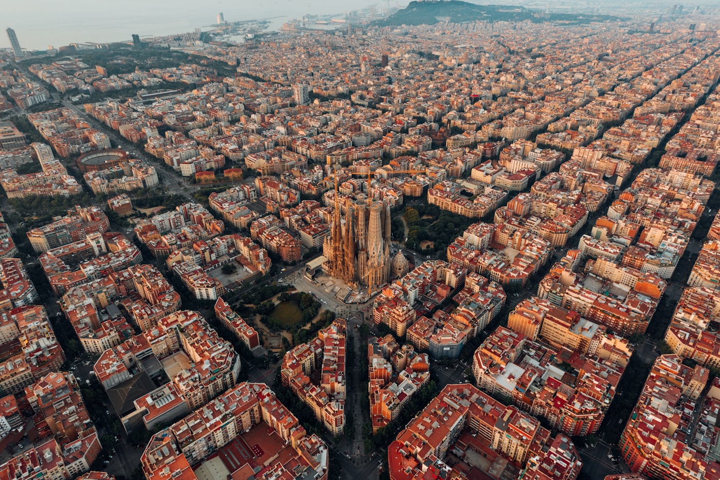 Park Güell at sunrise with colorful mosaic tiles overlooking the Barcelona cityscape and the Mediterranean Sea