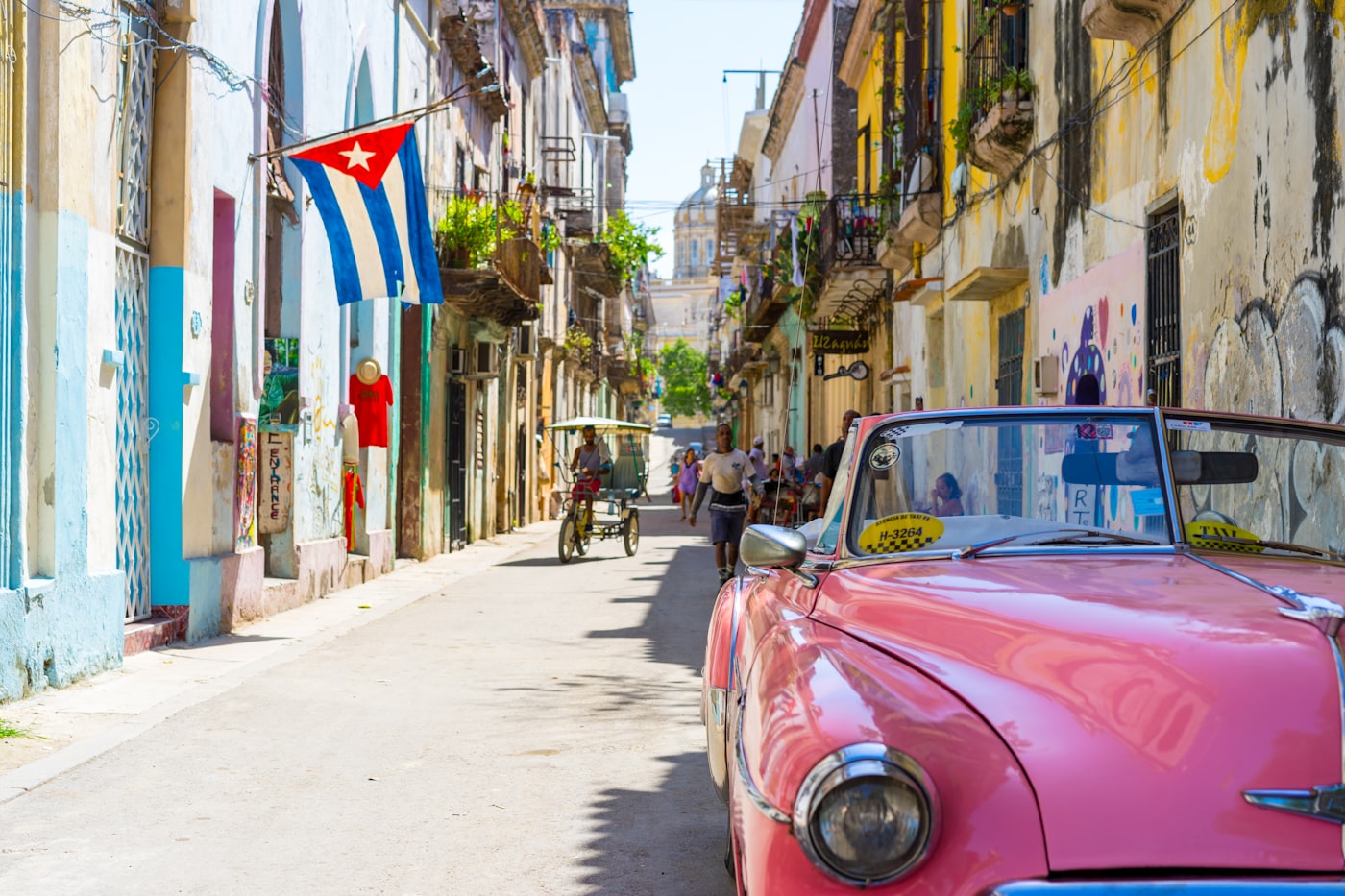 Classic 1950s American cars parked along the colorful crumbling colonial streets of Old Havana