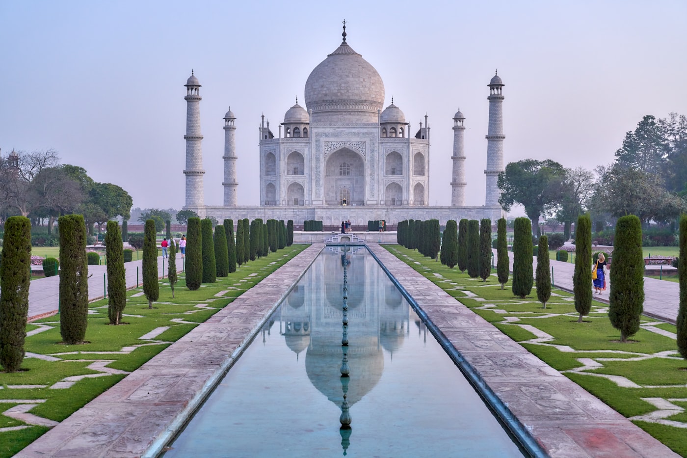 The Taj Mahal reflecting in the water at sunrise