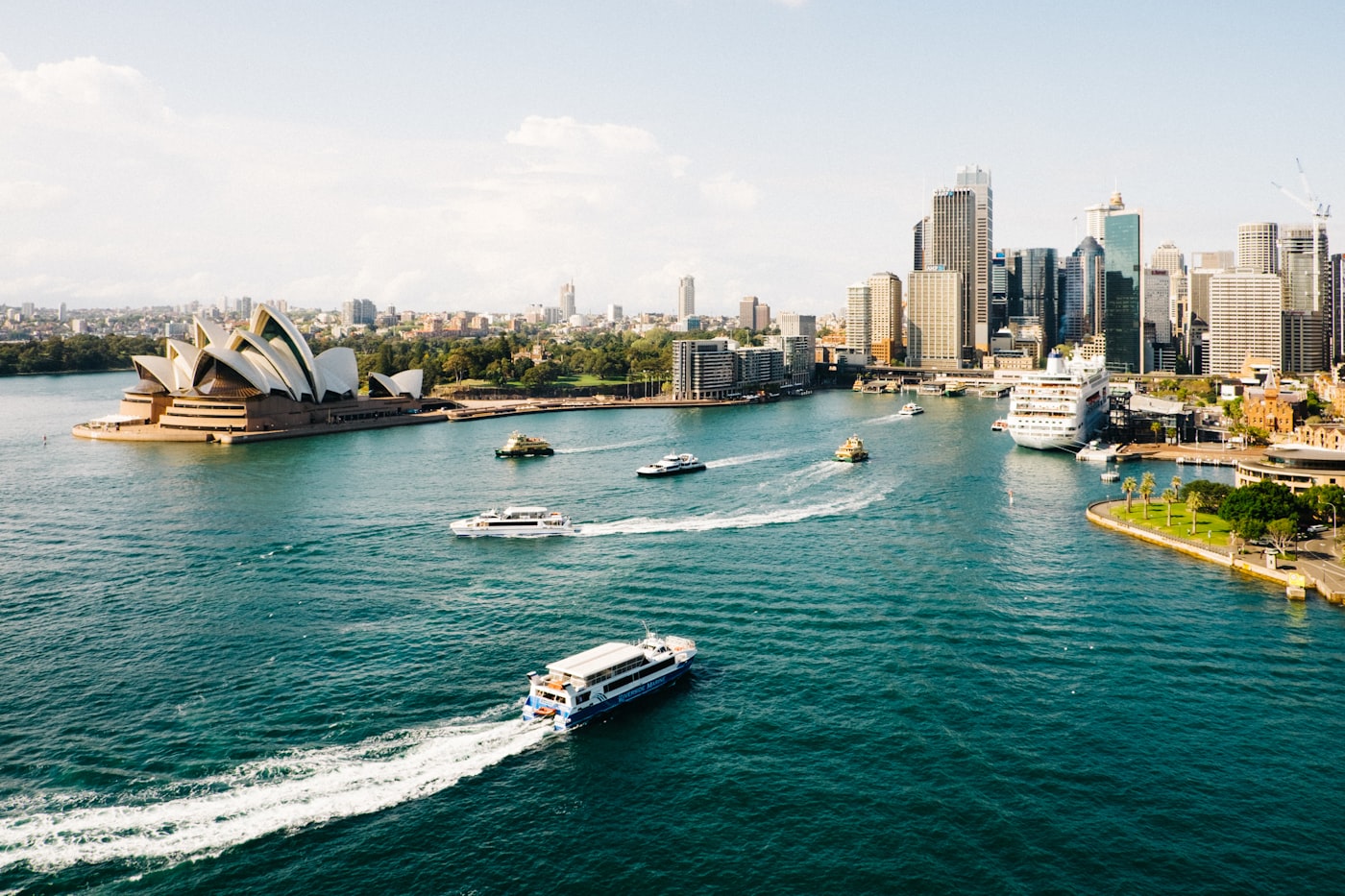 The iconic Sydney Opera House and Harbour Bridge bathed in warm golden sunset light